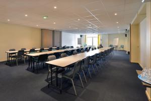 uma sala grande com mesas e cadeiras numa sala de aula em Soleil et Jardin em Solaize