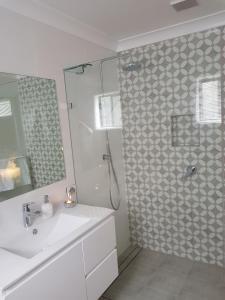 uma casa de banho branca com um chuveiro e um lavatório. em Irongate Studio B&B em Mintaro