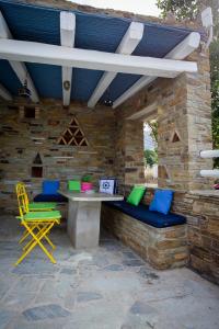 un patio con tavolo e sedie su un muro di pietra di Irene Studios a ayios Petros