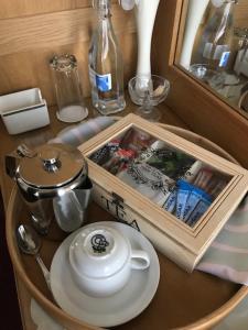 a table with a tray with a tea pot and a plate at The Firs Guesthouse in Runswick