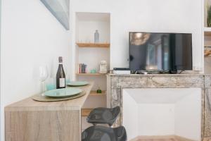 トゥールーズにあるLe Vert d'Eau - Rue Riquet - Terrasseのテーブル、テレビ、椅子が備わる客室です。
