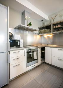 a kitchen with white cabinets and stainless steel appliances at Amber View 14th Floor in Klaipėda