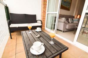 een houten tafel met twee glazen sinaasappelsap erop bij Letmalaga Economy Gevora in Málaga