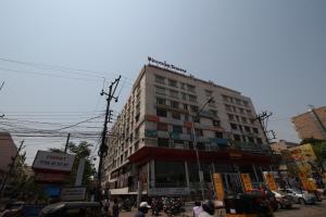 un grand bâtiment dans une rue animée de la ville dans l'établissement Minerva Grand Secunderabad, à Hyderabad