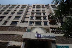 un edificio con un cartel de corte de ropa de hombre delante de él en Minerva Grand Secunderabad, en Hyderabad