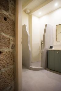 Zimmer mit einer Steinmauer, einem Tisch und einer Theke in der Unterkunft Pyrgos Stone House in Emporeiós
