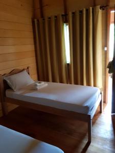 um quarto com uma cama e uma janela com cortinas em Amazon Arowana Lodge em Careiro