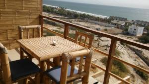 een tafel en stoelen op een balkon met uitzicht op het strand bij Altavista Casa de Huespedes in Vichayito