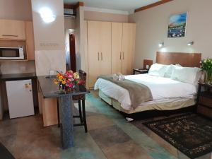 een hotelkamer met een bed en een tafel met bloemen erop bij Kyalami Lodge in Midrand