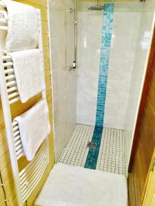 y baño con ducha y azulejos azules y blancos. en Chalet Free Sauna & Spa SuperKing bed en Killaloo