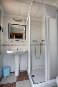 un bagno bianco con doccia e lavandino di Hotel Sevilla a Almería Altre 27 foto