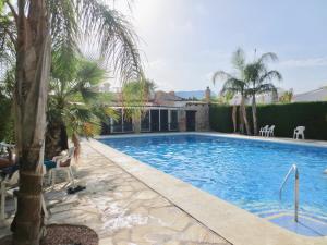 basen z palmami i dom w obiekcie Clubrent - Townhouse La Merced w mieście Calpe
