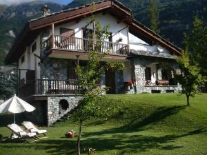 a house with a balcony and a grass yard at strada antica in Novalesa