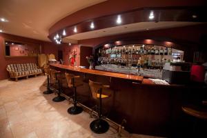 a bar in a room with a counter and stools at Zvezda Zhiguley Hotel in Tolyatti