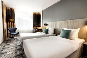 een hotelkamer met twee bedden en een stoel bij Hotel International Brno in Brno
