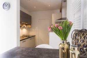 un jarrón de tulipanes rosas sentado en una mesa en una cocina en Strandzand, en Noordwijk aan Zee