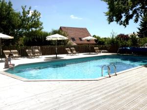 a swimming pool with chairs and umbrellas in a yard at CityKamp Colmar in Horbourg +25 photos