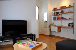 a living room with a flat screen tv and a table at Villa Bea in Giardini Naxos