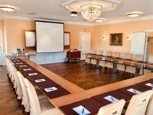 a conference room with tables and chairs and a screen at Hotell Torpa Pensionat - Sweden Hotels in Södertälje