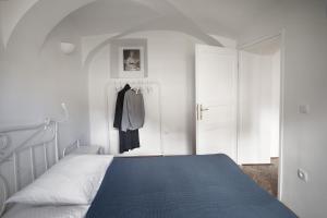 een witte slaapkamer met een bed en een kast bij River and Castle View Apartment Rose Tour As Ljubljana in Ljubljana