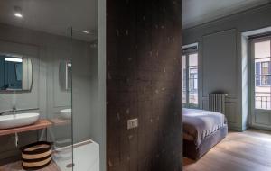 a bathroom with a bed and a sink and a mirror at Suites Menaggio in Menaggio