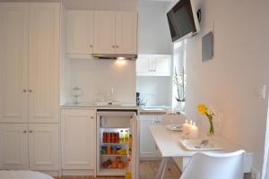 a small white kitchen with a small refrigerator in it at Agapi Suites in Chania