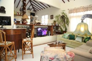 sala de estar con sofá y TV en Pousada Solar Dos Corais, en Búzios