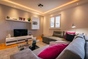 a living room with a couch and a television at Apartments Danigo in Budva