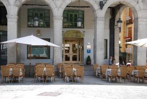 a group of tables and chairs in front of a building at Hotel Infanta Isabel by Recordis Hotels in Segovia