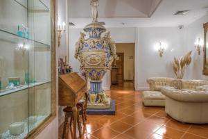 ein Wohnzimmer mit einer großen Vase in einem Zimmer in der Unterkunft Hotel Atlantic Palace in Florenz