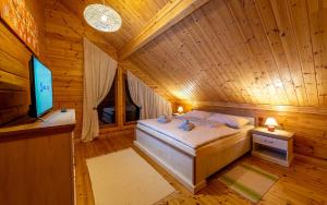 a bedroom with a bed in a wooden room at Chata Nikol in Vysoke Tatry - Tatranska Lomnica.