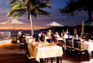 パトンビーチにあるSafari Beach Hotel - SHA Extra Plusのレストランの席に座る人々