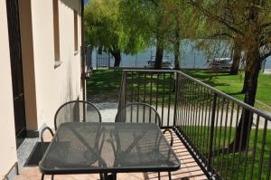 un tavolo e sedie su un balcone con vista sull'acqua di North Wind Camping & Apartment a Domaso