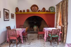 a dining room with two tables and a fireplace at Hotel Bodega el Moral in Ribera del Fresno