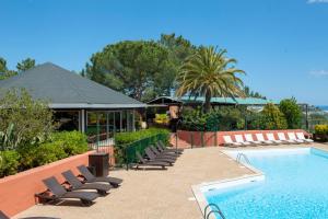 - une piscine avec des chaises longues à côté d'un complexe dans l'établissement Residence Castell'Verde, à Porto-Vecchio