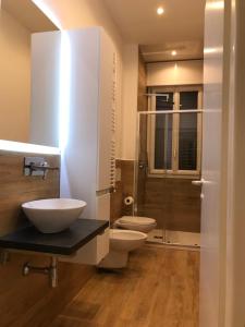a bathroom with two toilets and a glass shower at Riva reno 54 rooms in Bologna