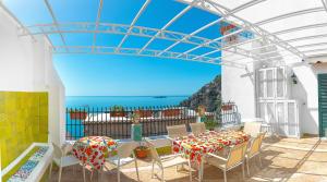 une terrasse avec une table et des chaises et l'océan dans l'établissement Casa Nilde, à Positano