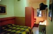 a bedroom with a bed and a desk in it at Hotel Tre Santi in Treviso