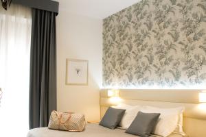 een slaapkamer met een bed met bloemenbehang bij Hotel La Conchiglia in Bellaria-Igea Marina