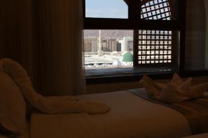 a bedroom with a bed and a window with a view at Manazeli Madinah in Medina