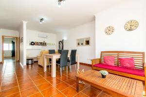 サンタ・ルジアにあるSanta Luzia Residence Apartamento T2 com Piscina & Wi-Fiのリビングルーム(赤いソファ、テーブル付)