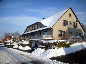 uma casa com neve na berma da estrada em Haus Hannover em Carolinensiel