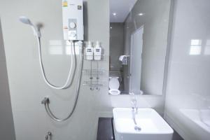 a white bathroom with a shower and a sink at THAMM Residence in Nakhon Ratchasima