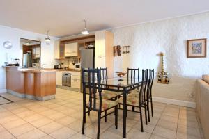- une cuisine et une salle à manger avec une table et des chaises dans l'établissement 9 The Village, à Hout Bay