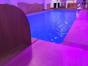 una piscina con iluminación púrpura en un edificio en Dimora nel Benessere, en Monopoli