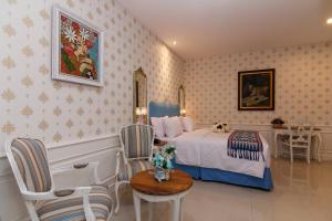 Un dormitorio con una cama y una mesa y sillas. en M Home, en Yakarta
