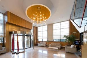 a large lobby with a chandelier and chairs and tables at Crisol Vía Castellana in Madrid