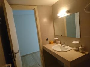 Appartement Hay Riad في الرباط: حمام مع حوض ومرآة