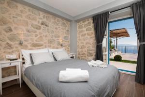 Villa Mara في زاووستروج: غرفة نوم بسرير وجدار حجري