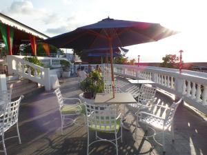 a table and chairs with an umbrella on a deck at Sky Club @ Montego Bay Club Resort in Montego Bay